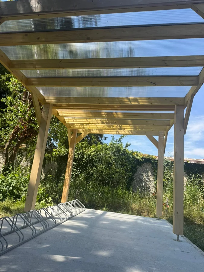 Charpente de pergola — Ossature bois d'une pergola posée sur dalle béton, avant couverture